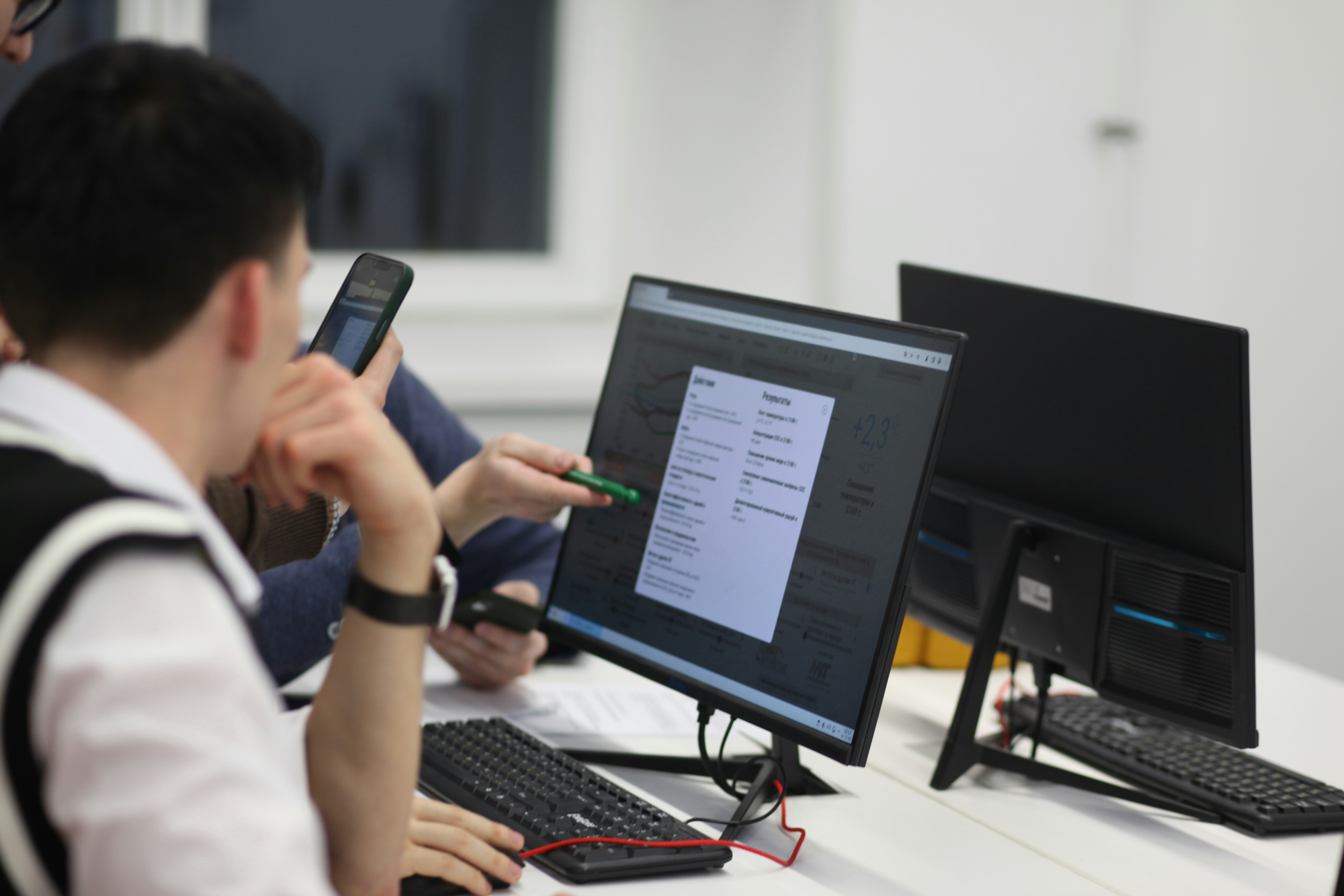 image shows students working at a computer in a modular classroom